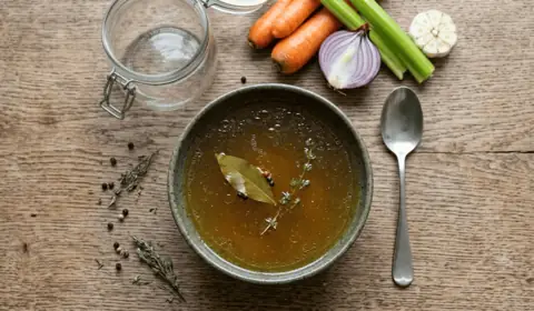 Caldo de huesos casero con laurel y tomillo, zanahoria, apio y cebolla