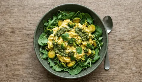 Huevos revueltos al curry con brócoli, pesto y rúcula en bol