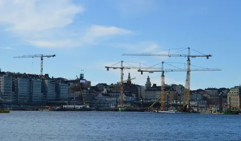 Ciudad portuaria en obras, con varias grúas trabajando sobre los edificios
